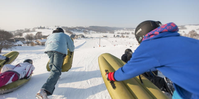 Deux personnes pratiquent l'airboard sur une piste de ski