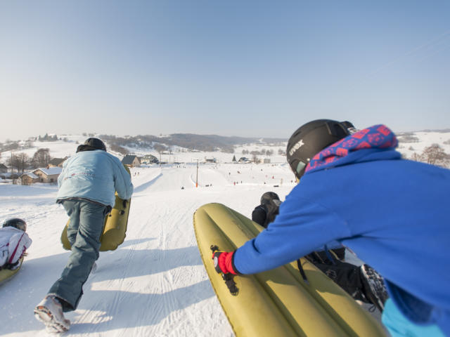 Deux personnes pratiquent l'airboard sur une piste de ski