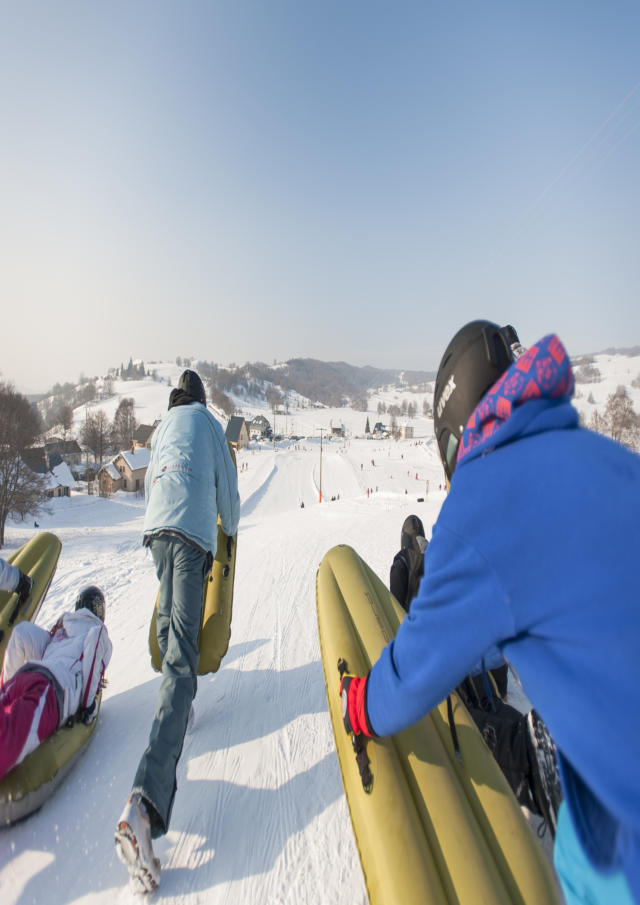 Deux personnes pratiquent l'airboard sur une piste de ski