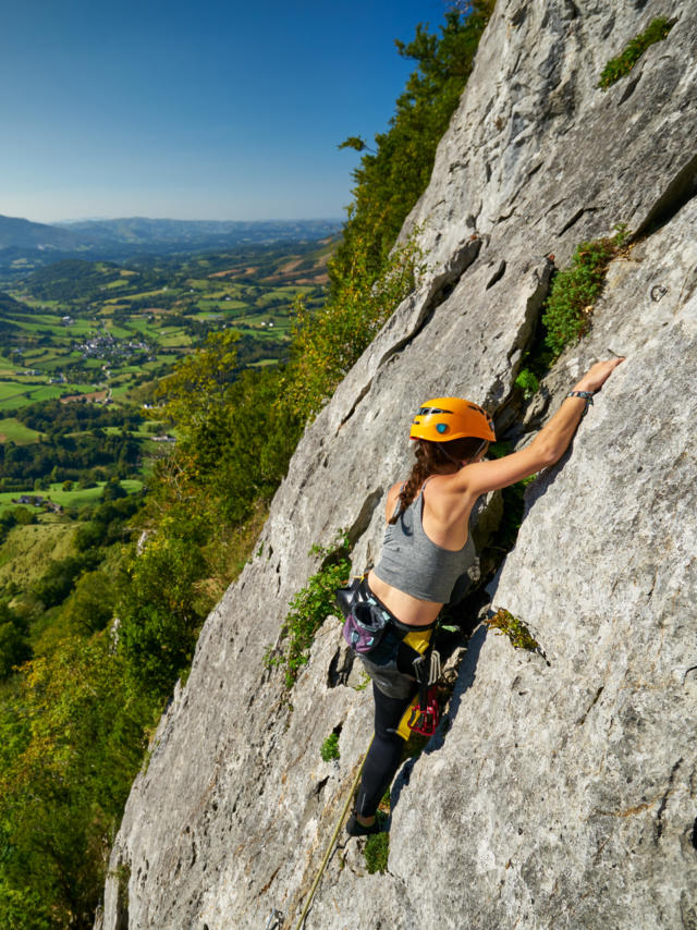 Una deportista escalando el acantilado Arguibelle en Lanne en Baretous