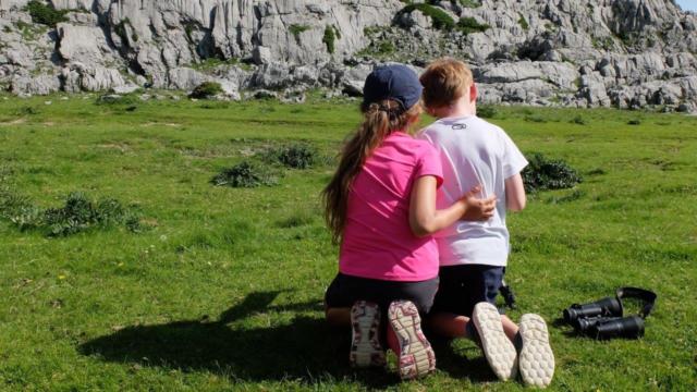 Deux enfants observent une marmotte en montagne