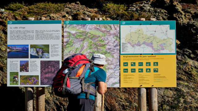 Pèlerin de St Jacques de Compostelle observe des panneaux du Parc National des Pyrénées