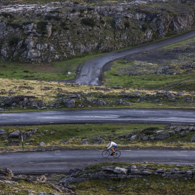 Une cycliste sur une route de montagne