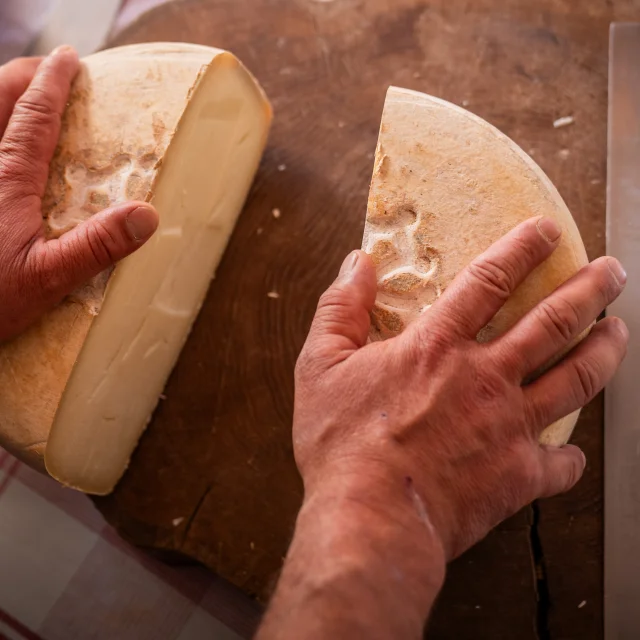 fromage coupé en deux sur un plateau en bois qui est posé sur une table